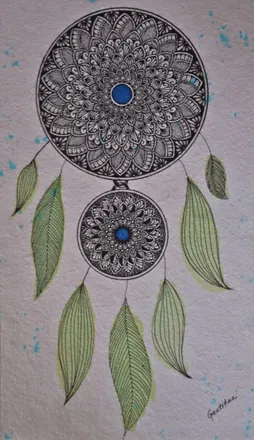 Two dreamcatchers of fine pattern hung with green leaves