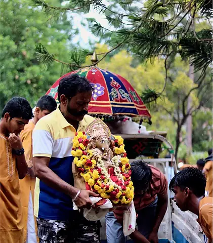 A group gathered outdoors with flower garlands