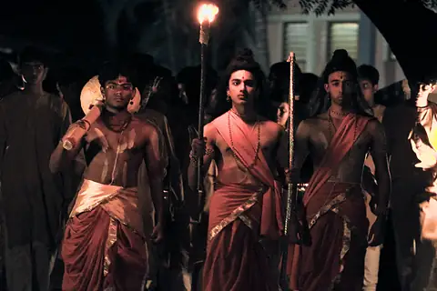 Students in costume walking in procession by the light of flaming torches