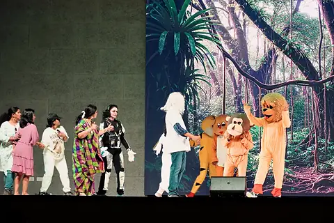 CIRS teachers in costume performing a skit before a jungle backdrop on Children's Day