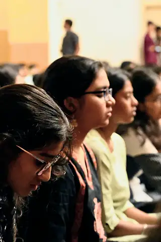 Students seated in a hall, listening