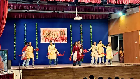 Junior school students in costume performing a group dance on stage in the MPH