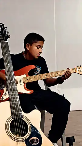 A student playing guitar at the Inter-House Solo Instrumental Competition