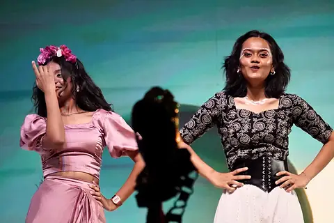Two performers side by side, one with flowers in her hair