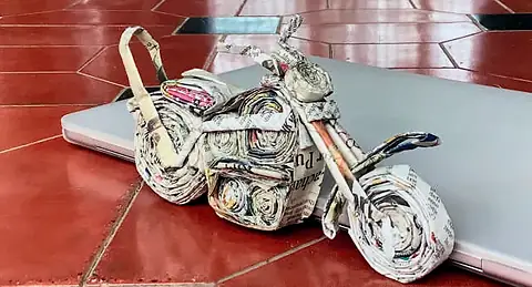 Photograph of a motorcycle made of rolled newspaper, on a red floor
The Crossroads, Issue 28 · Pongal issue