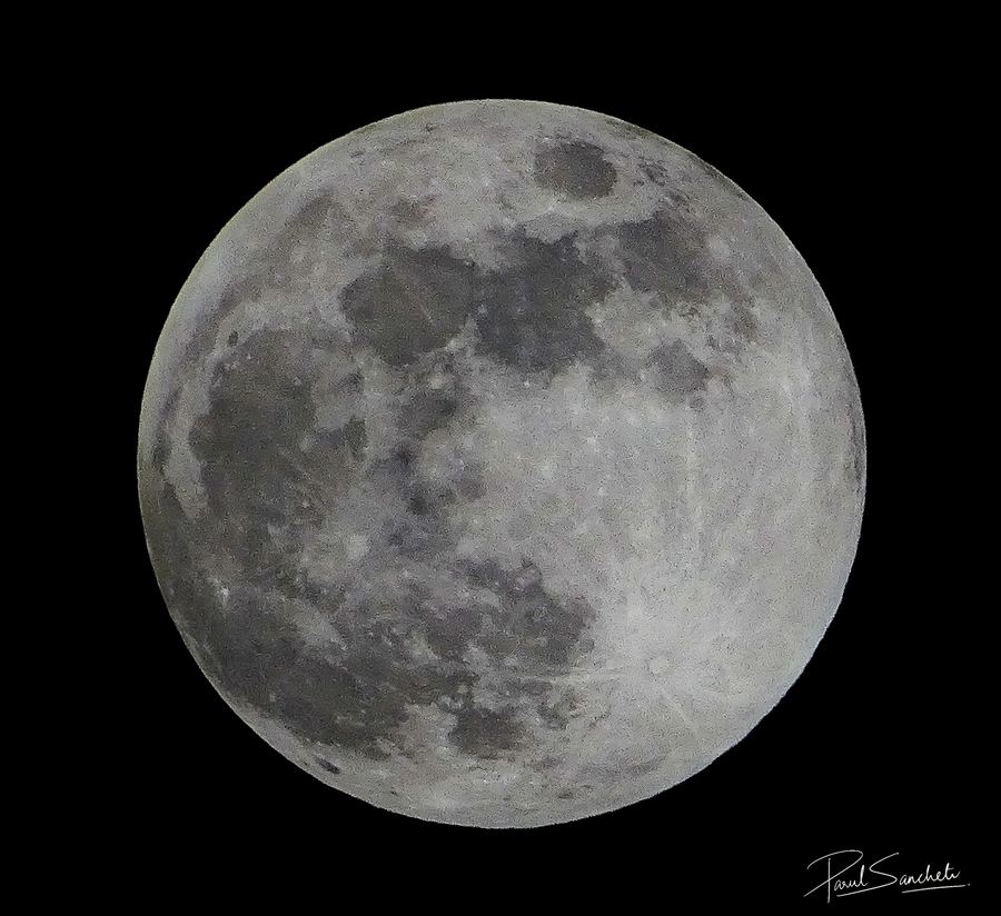 A bright full moon against a black sky