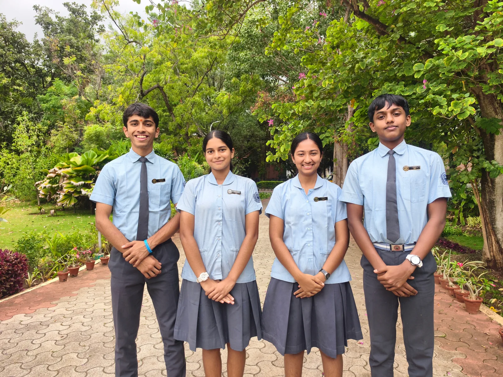 The four Sports Secretaries of the Student Council 2026–27 standing in a row on a brick path in the garden