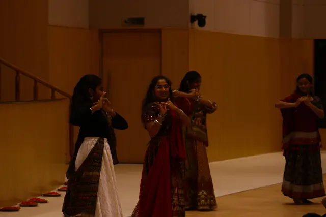 Girls in mirrored skirts dancing in the hall under warm light