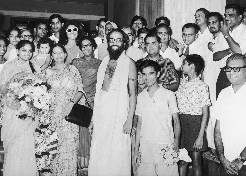 Swami Chinmayananda welcomed by a community gathered around him
