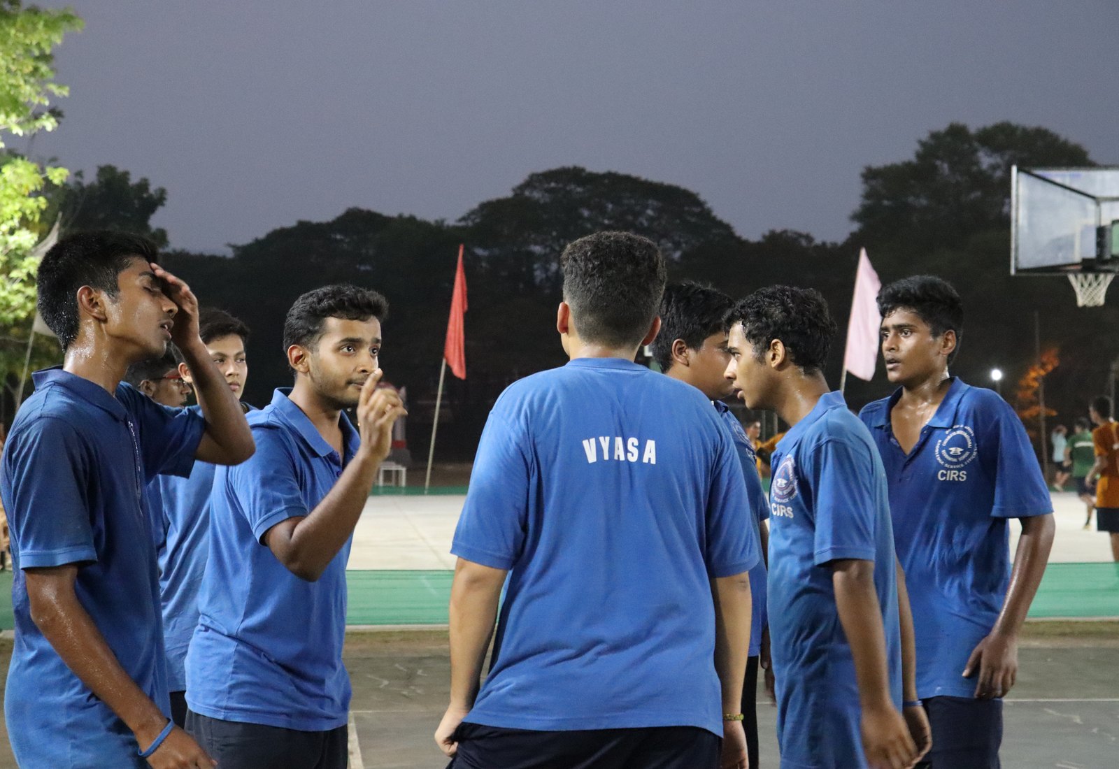 Vyasa players talking courtside in named blue shirts