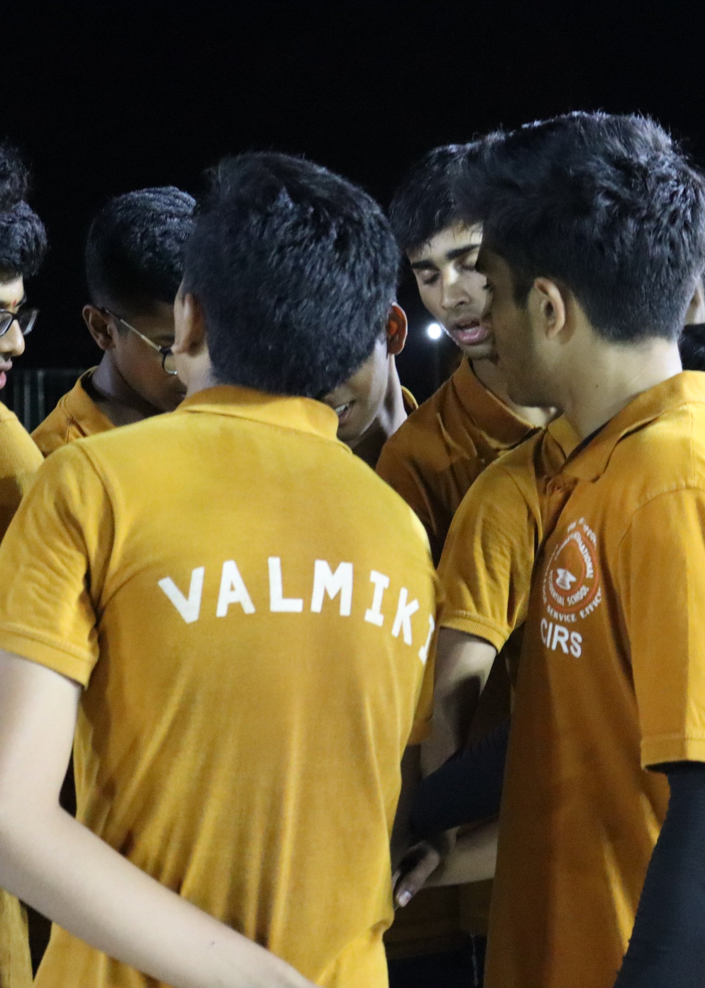 Valmiki players gathered in yellow shirts with the house name across their backs