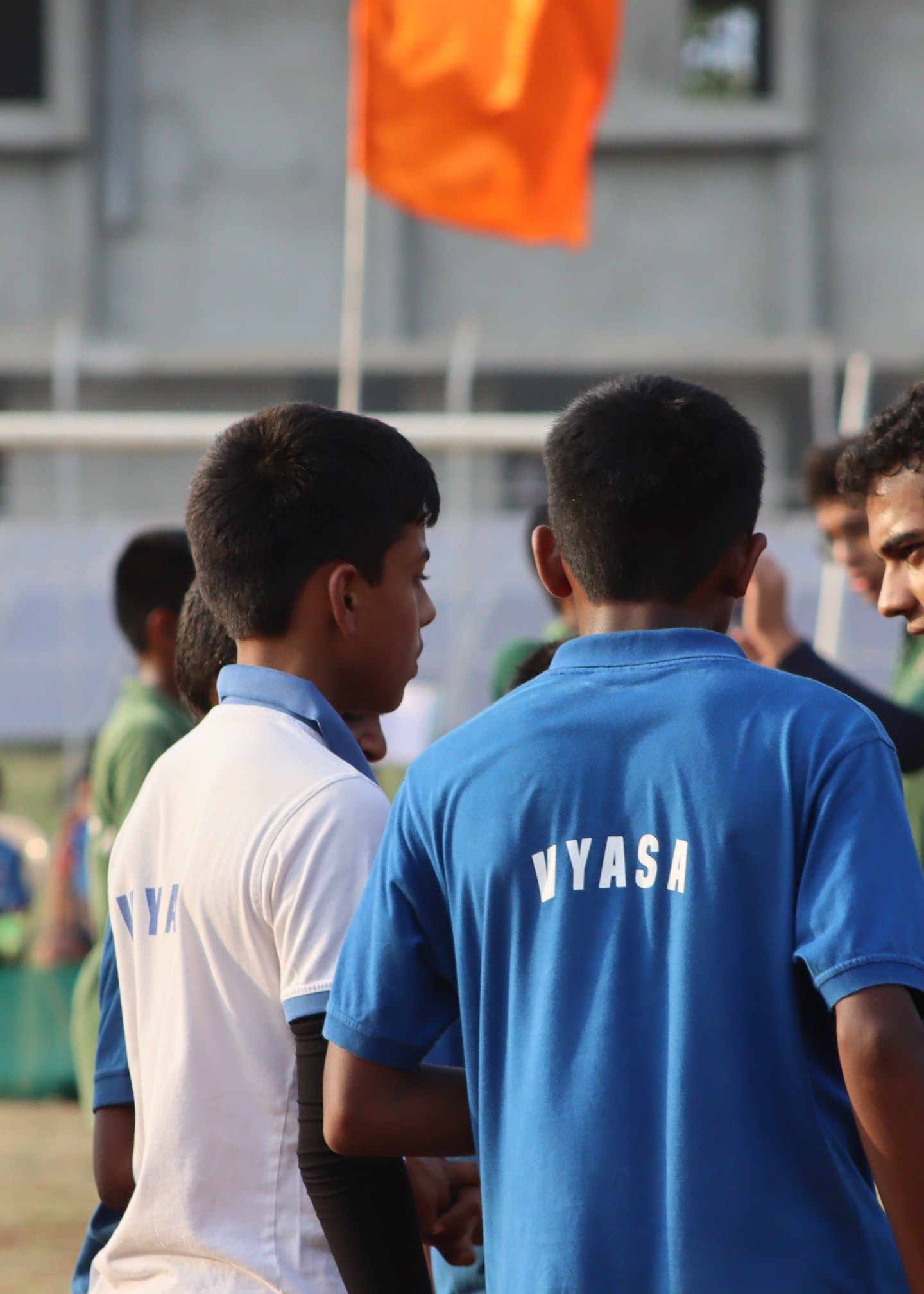 Vyasa players gathered courtside, with the house name on a blue shirt