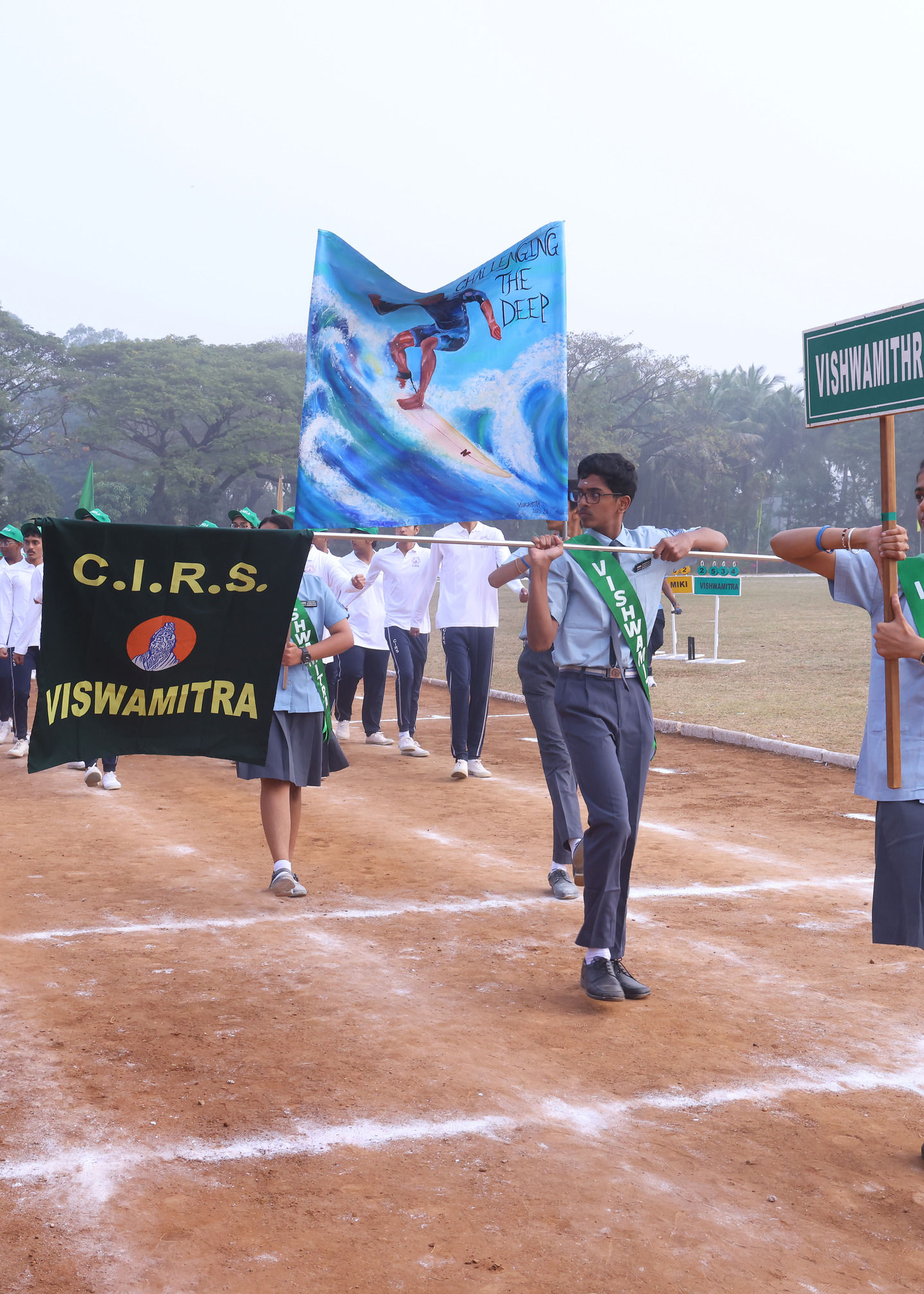 Vishwamitra students marching with their named house banner and flag
