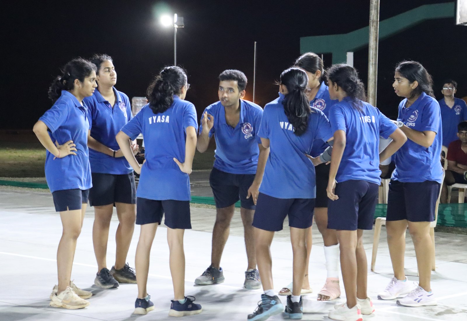 Vyasa players in a basketball huddle, their house name visible on blue shirts