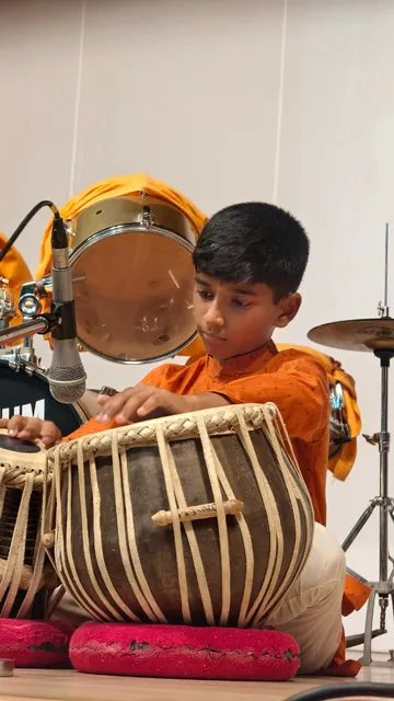 A student playing tabla at the Inter-House Solo Instrumental Competition