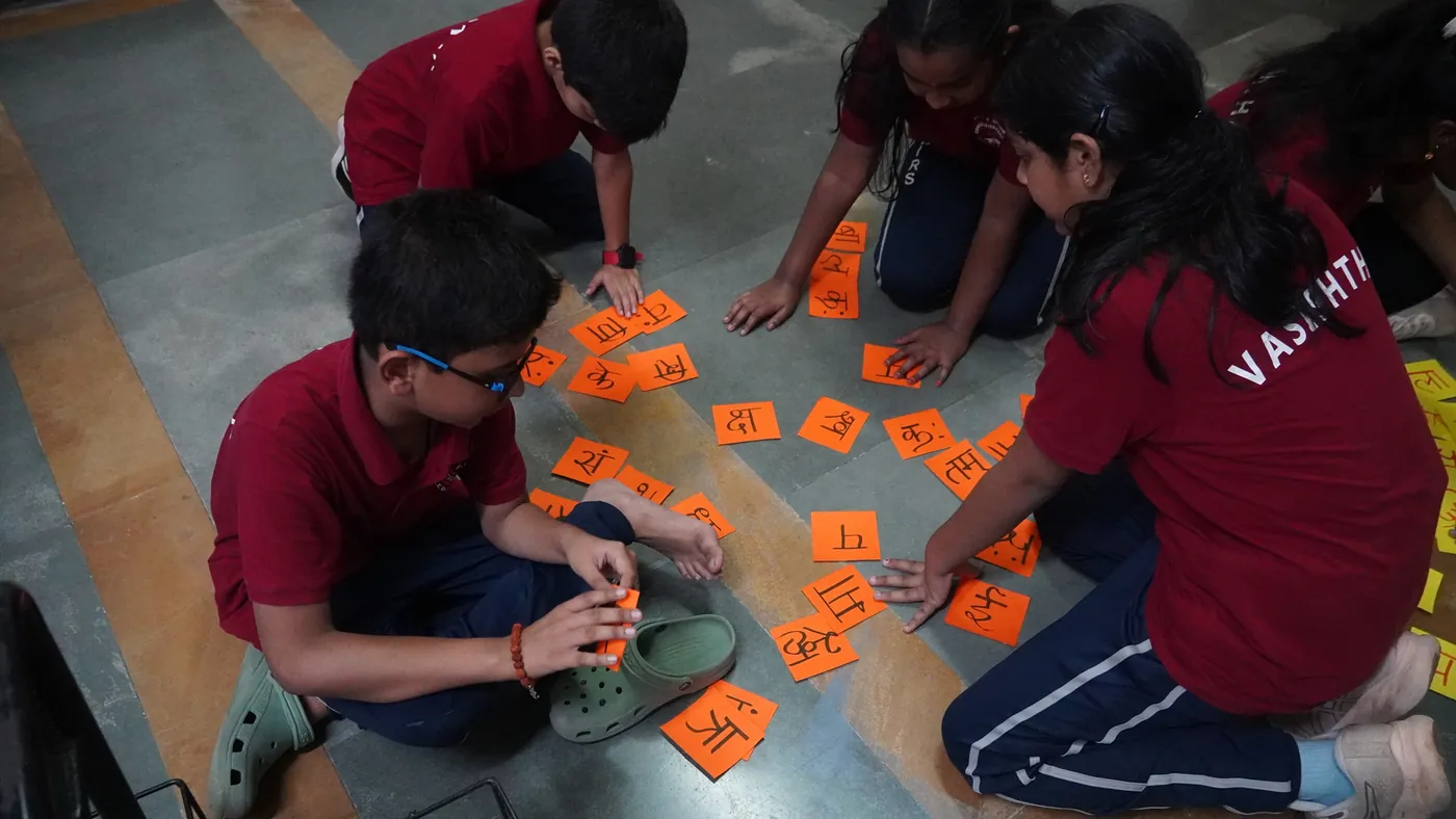 Students arranging letter cards on the floor during Language Week