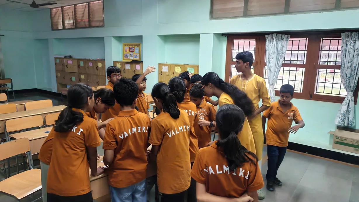 Students in mustard house shirts crowded around a table