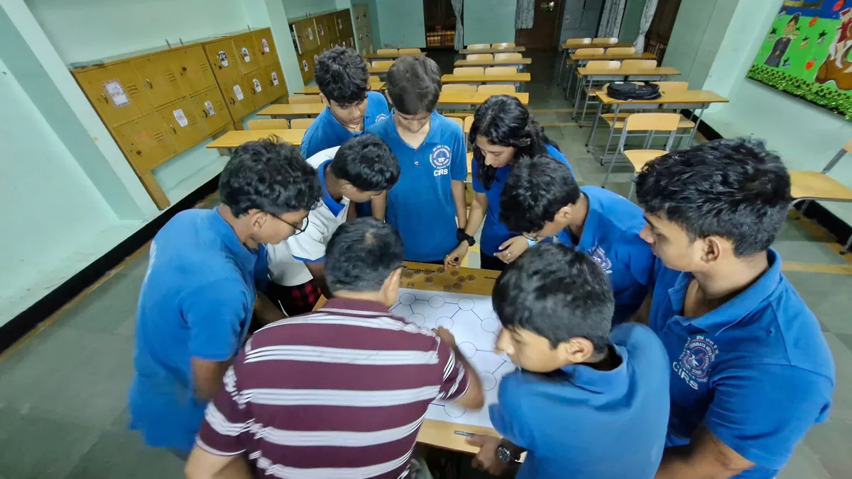 Students in blue shirts gathered around a table