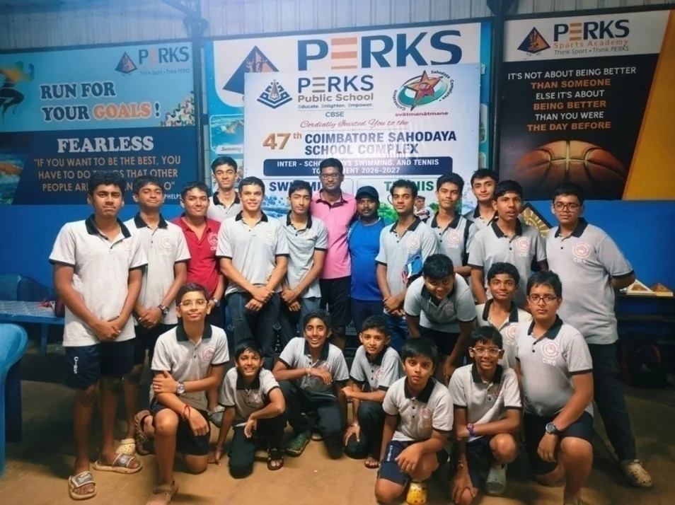 A large group of boys in grey shirts posing before Perks Public School Sahodaya swimming banners