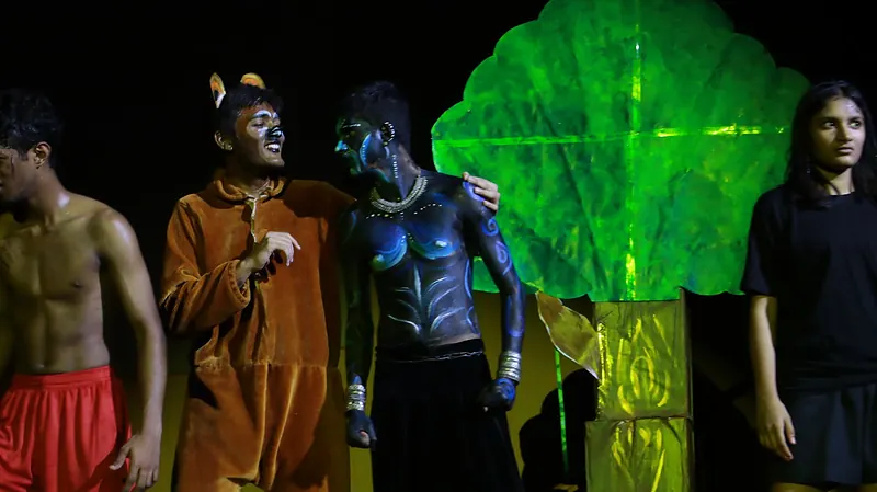 Actors in costume and body paint beside a glowing green tree
