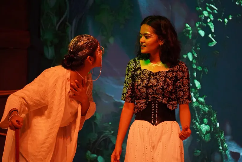 Two performers facing each other in warm light