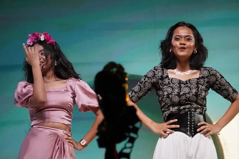 Two performers side by side, one with flowers in her hair