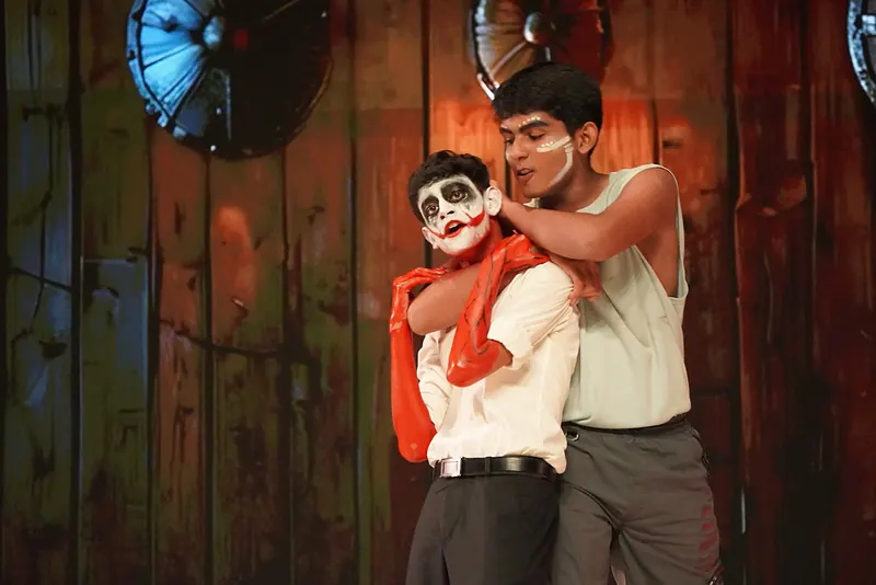 An actor holding another, in skull face paint, from behind