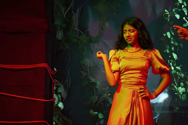 A performer in an orange satin dress, one hand on her hip