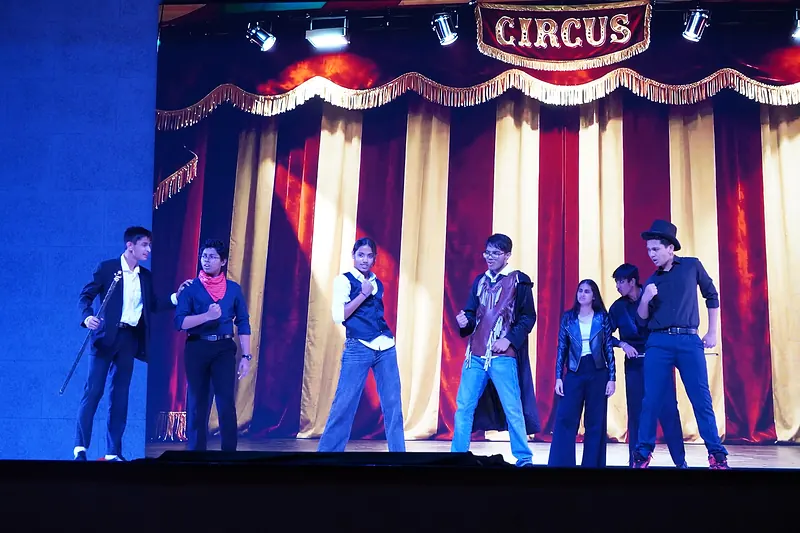 The company in a line before red-and-white striped curtains, beneath a sign reading Circus
